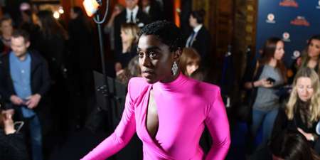 Lashana Lynch at an event wearin a maroon dress without her boyfriend.
