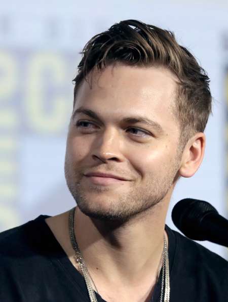Alexander Calvert answering questions at comic-con while talking about Supernatural.