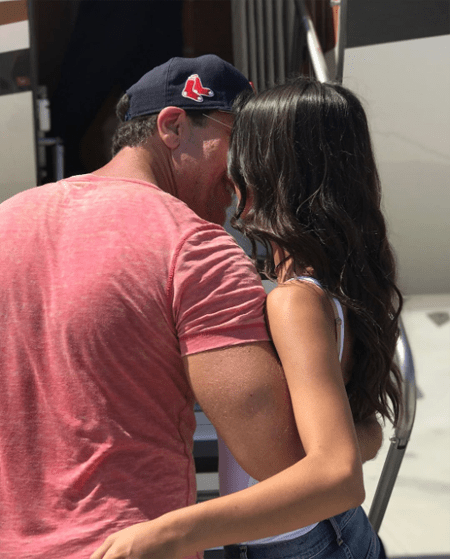 Dane Cook kissing girlfriend Kelsi Taylor in front of a jet.