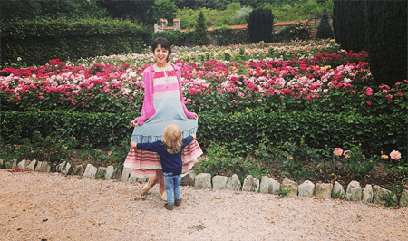 Annet and her daughter in front of a flower garden.