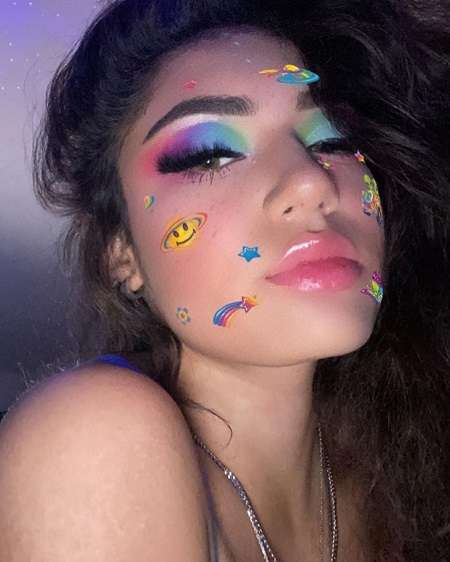 Avani Gregg in a colorful face makeup with cosmos elements.
