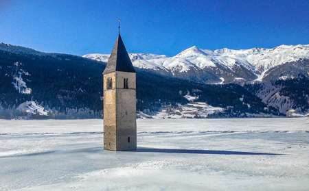 The lake of Curon freezes over during the winter and people can walk up to the base of the bell tower.