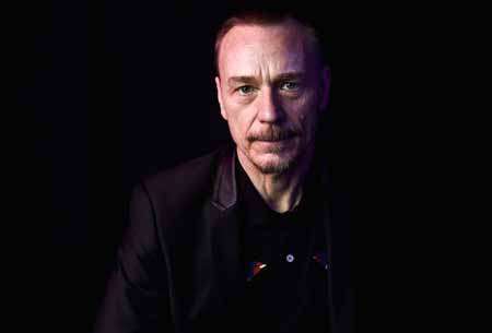 Ben Daniels in a black surrounding wearing a black shirt.