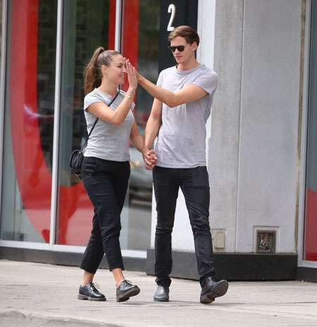 Alida Morberg and Bill Skarsgard high five while walking hand in hand.