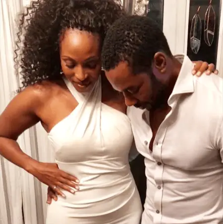 Lisa Berry and Dion Johnstone both wearing white and looking down at her foot.