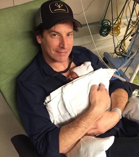 Rob Huebel holding his newborn daughter for the first time in the NICU.