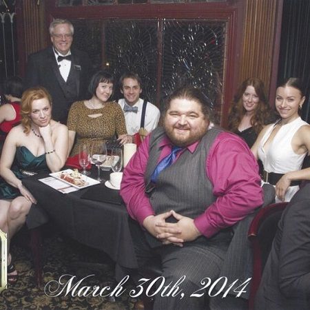 7 people at a dinner table turning at the camera. Jorge and his wife, Rebecca on the opposite sides of the table.